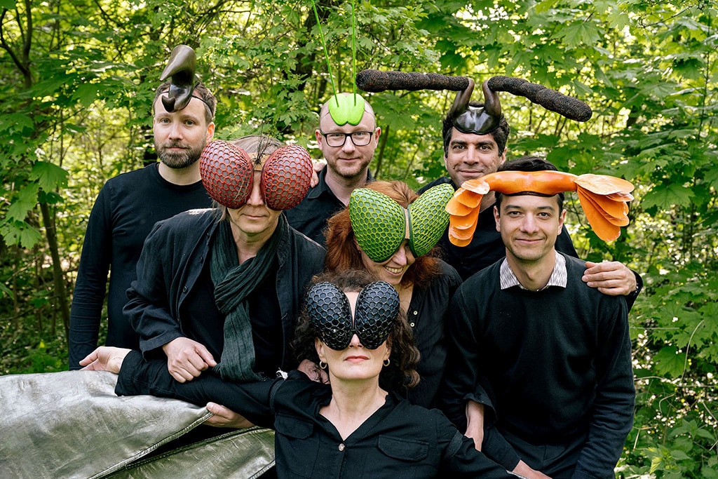 Gruppenbild Projekt Stumm Herum das Ende vom Lied, alle Künstler mit Insektenmasken in einer Grünfläche